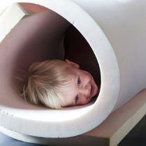 Zdjęcie uśmiechniętego dziecka w tubie z gąbki.