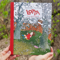 Zdjęcie ksiązki pod tyułem "Lotta. Trzy opowiadania" trzymana w dłoniach. W tle zieleniące się krzewy.