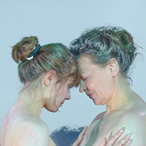 Dwie kobiety, młodsza i starsza, naprzeciwko siebie, dotykają się czołami.