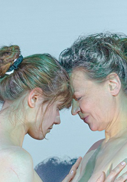 Dwie kobiety, młodsza i starsza, naprzeciwko siebie, dotykają się czołami.