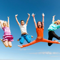 Dzieci skaczące w góre na tle nieba.