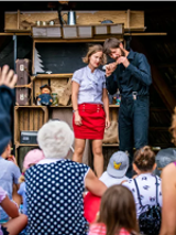 Na zdjęciu znajduje się mężczyzna oraz kobieta na scenie.