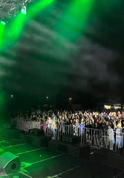 Mężczyzna na scenie w zielnym świetle, przed nimi publiczność.