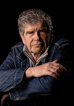 Zdjęcie Lecha Dyblika, który patrzy na wprost, ciemne tło.