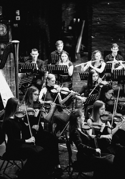 czarno-białe zdjęcie orkiestry na scenie, podczas koncertu