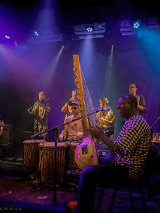 Zespół muzyczny z afrykańskimi instrumentami podczas występu na scenie.