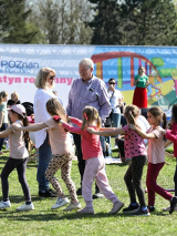 Zdjęcie przedstawia kilka osób, dzieci, mężczyznę oraz kobietę bawiących się na festynie