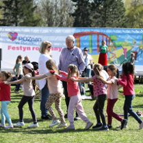 Zdjęcie przedstawia kilka osób, dzieci, mężczyznę oraz kobietę bawiących się na festynie