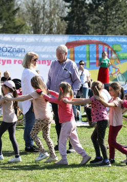 Zdjęcie przedstawia kilka osób, dzieci, mężczyznę oraz kobietę bawiących się na festynie