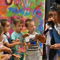 Na zdjęciu znajduje się grupka dzieci wraz z panią prowadząća warsztaty. Dzieci są w kółku i słuchają o czym opowiada prowadząca.