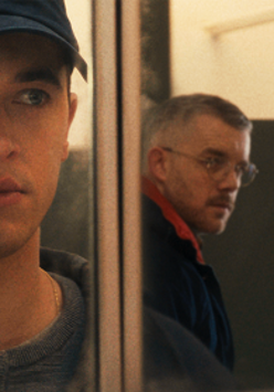 Zdjęcie mężczyzny, który w odbiciu w lustrze widzi innego mężczyznę, który na niego patrzy.