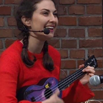 Zdjęcie kobiety grającej na ukulele.