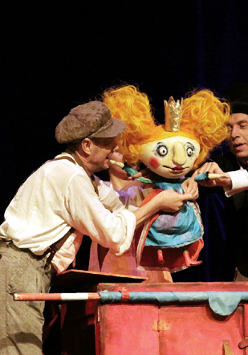 Zdjęcie aktorów z lalką w trakcie spektaklu.