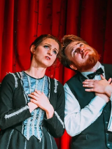 Mężczyzna i kobieta, stojący obok siebie z uniesionymi twarzami ku górze i złożonymi rękami na piersiach.