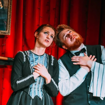 Mężczyzna i kobieta, stojący obok siebie z uniesionymi twarzami ku górze i złożonymi rękami na piersiach.