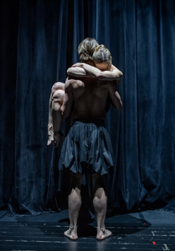 na scenie stoi tancerz, odwrócony tyłem, na rękach trzyma kobietę, która pochyla głowę do jego ramienia i obejmuje go za szyję