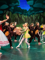 dziewczynka w czerwonej czapeczce razemz innymi dziećmi w kostiumach niedzwiedzi i pszczoł