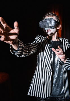 Zdjęcie kobiety w goglach na oczach z wyciągnietymi przed siebie rękoma.