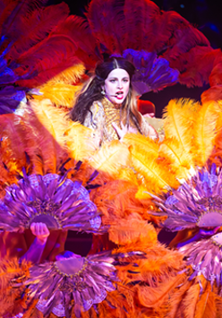 Kobieta wśród wachlarzy z kolorowych piór.