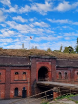 Wejście do starego, wojskowego fortu przez kładkę przewieszoną nad suchą fosą.