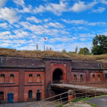 Wejście do starego, wojskowego fortu przez kładkę przewieszoną nad suchą fosą.