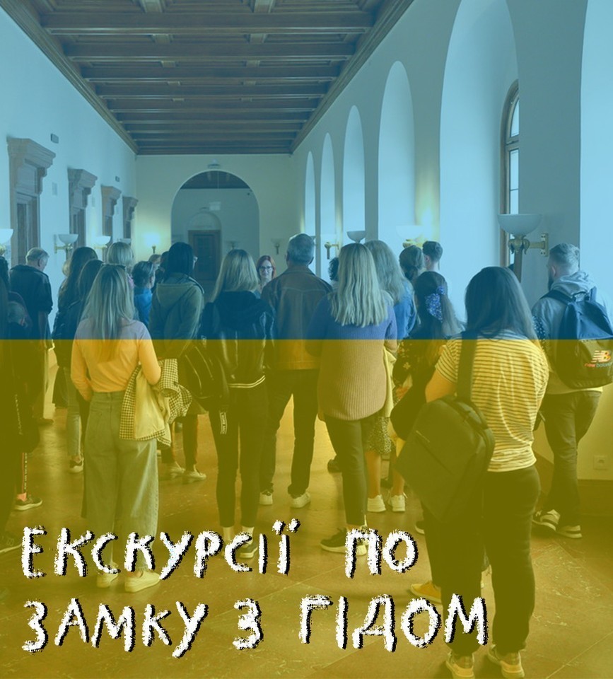Photo of group of people in a corridor, listening to a young woman. Blue and yellow colours.