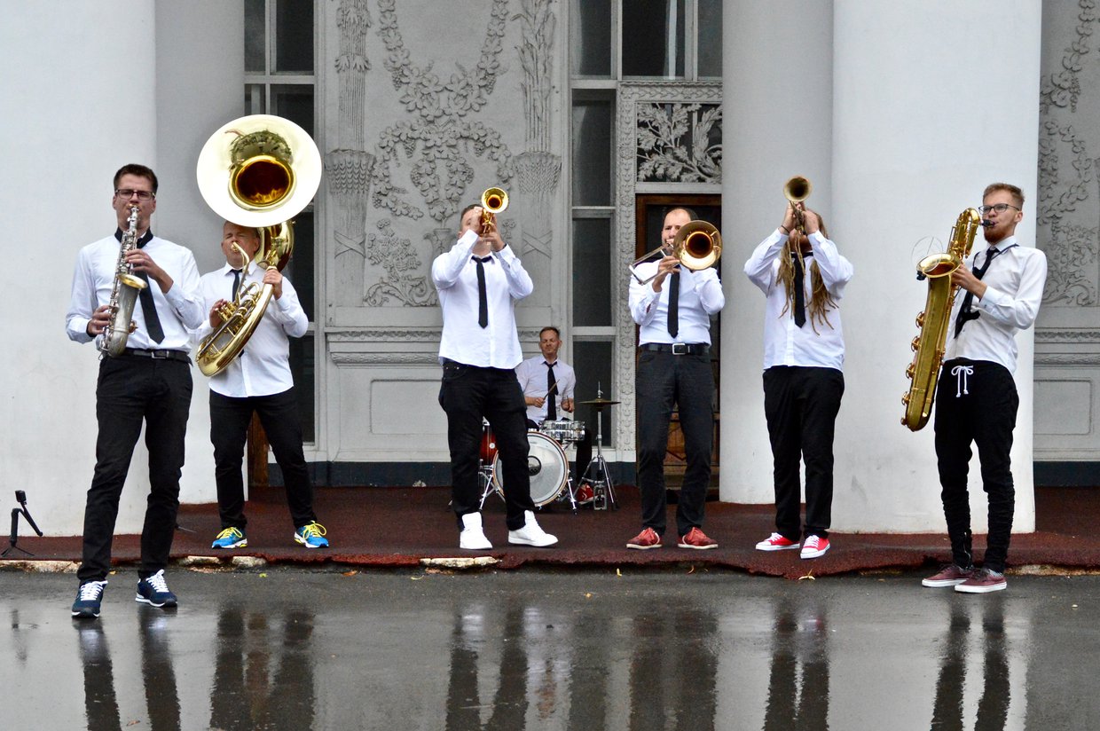 Photo of members of a band playing various musical instruments.