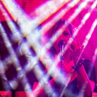 PIcture of a singing woman; picture in dark pink and violet colours.