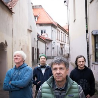 Photo of the band's members on a narrow street.