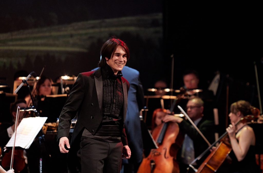 Photo of the artist; the orchestra in the background.