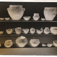 Photo of clay pots standing on shelves.