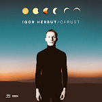 Album cover - photo of a singer in black clothes who stands straight. Brown-orange and blue background.