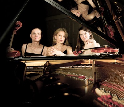 Picture of three women sitting at the grand piano