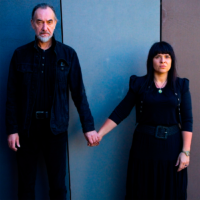 Photo of the artists - a man and a woman holding their hands