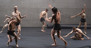 Picture from the performance - half-naked male dancers in dance poses on the stage