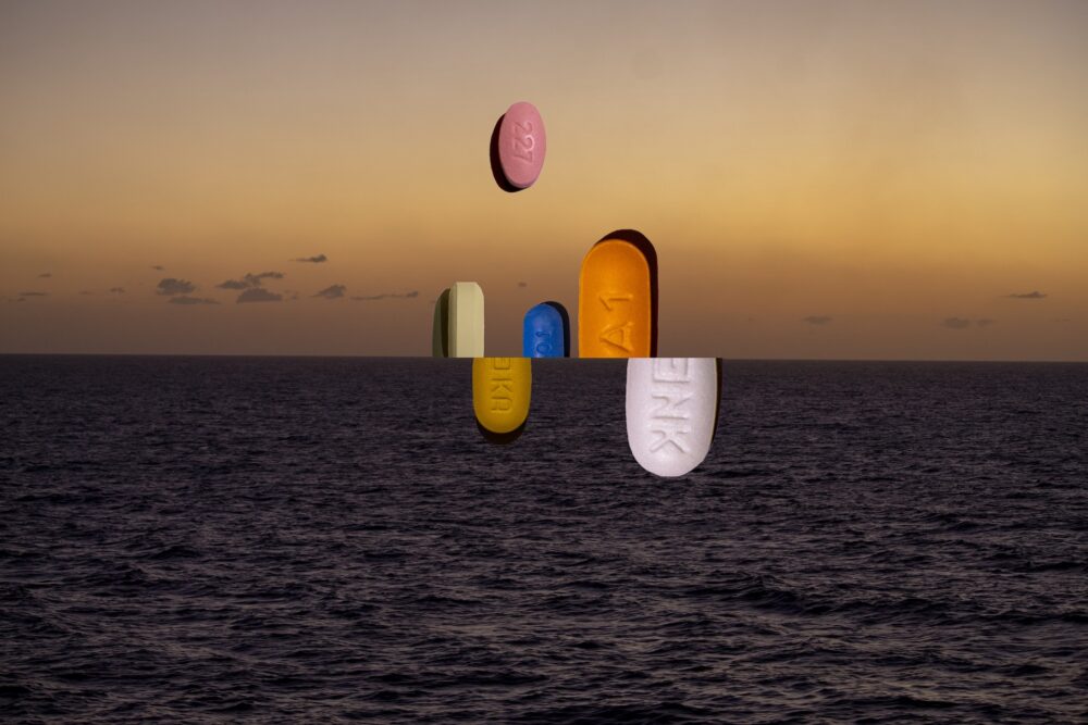 Picture of coloured pills which emerge from the sea or are under the sea's surface