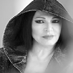 Black and white photo of the artist's face - a woman in a hood on her head.