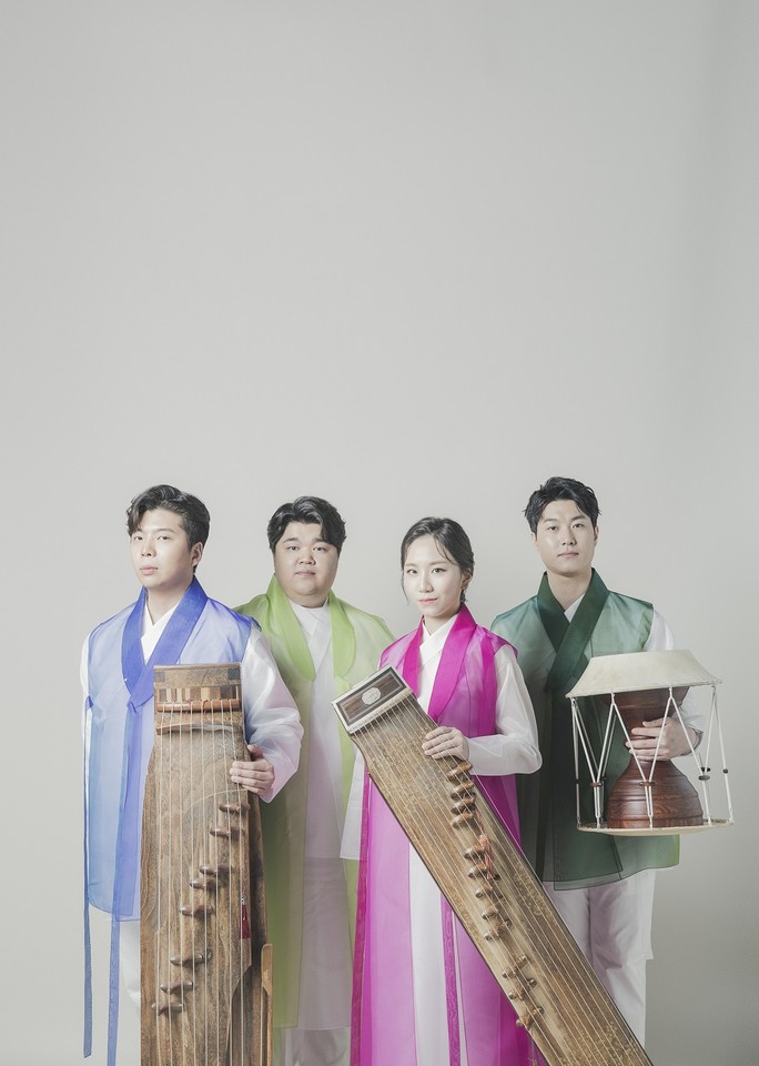 Photo of the band - three men and one woman stnding in their folk clothes with their musical instruments.