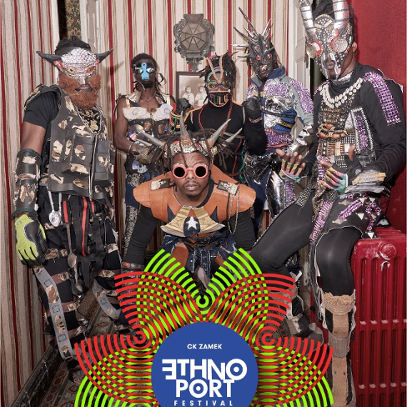 Six black men wearing fancy costumes, masks, and headbands/horns made of various materials.
