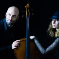 Photo of a man, a woman and a double bass between them.