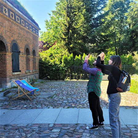 Dwie osoby przed budynkiem Śluzy robią zdjęcie.