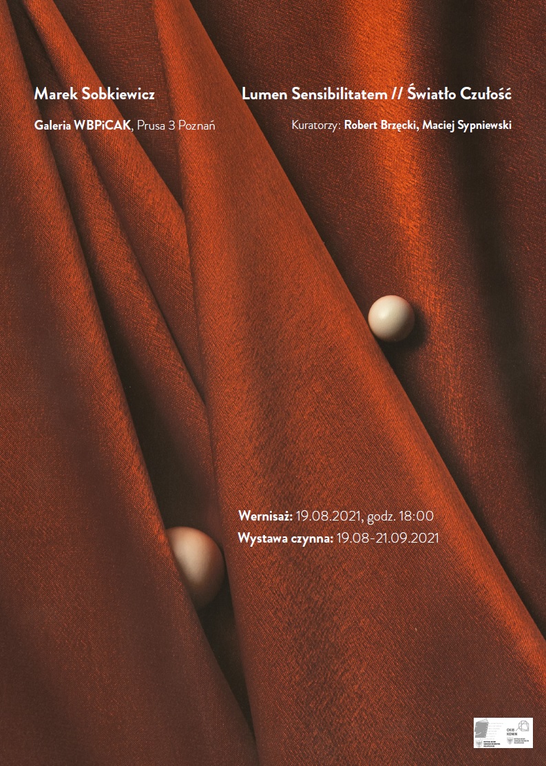 Dwie brązowe kulki na bordowym nieregularnie ułożonym materiale.