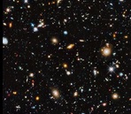 Zdjęcie przedstawia widok kosmosu z teleskopu Hubble'a. Różnobarwne gwiazdy świecą na ciemnym tle.