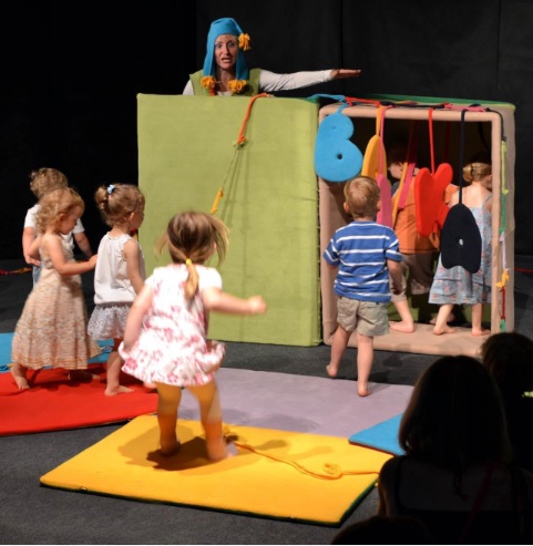 Zdjęcie dzieci i aktorki w trakcie spektaklu.