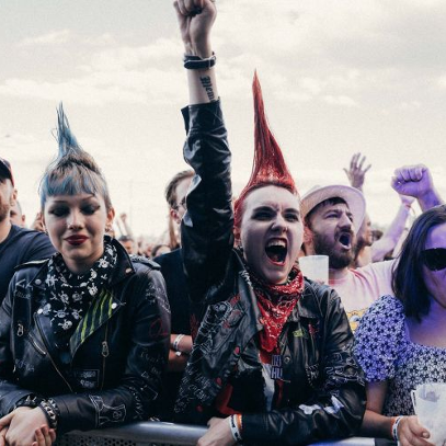 Dwie młode dziewczyny z kolorowymi irokezami na głowach w tłumie pod sceną.