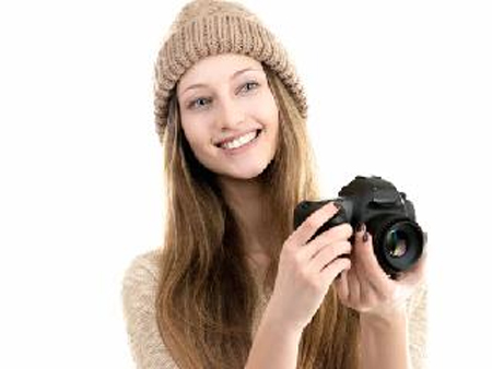Foto: dziewczyna w czapce z aparatem fotograficznym.