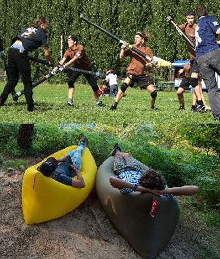 grupa chłopców walczy na trawie, 2 odpoczywa w canoe.