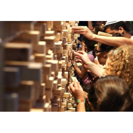 Ludzie wyjmuja z muru klocki.