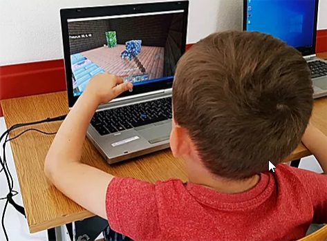 Dziecko najprawdopodobniej gra na laptopie.