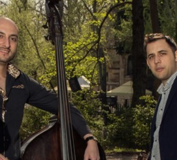Na pierwszym planie stoi czterech mężczyzn trzymających instrumenty muzyczne, dwóch cymbały (Balázs i Jenő), gitaręoraz kontrabas. Muzycy są elegancko ubrani. Na drugim planie znajdują się gęste drzewa, najprawdopodobniej jest to las.